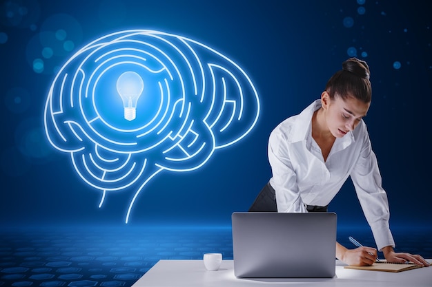 Attractive young european businesswoman leaning on desktop with laptop