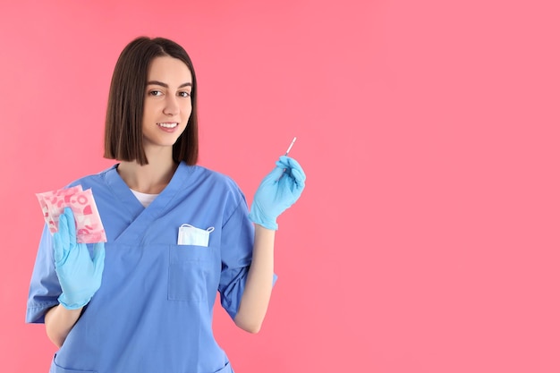 Attraente giovane dottoressa su sfondo rosa