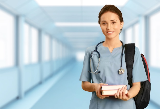 Привлекательная молодая студентка-врач на фоне