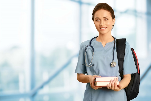 Attractive young female doctor student on background