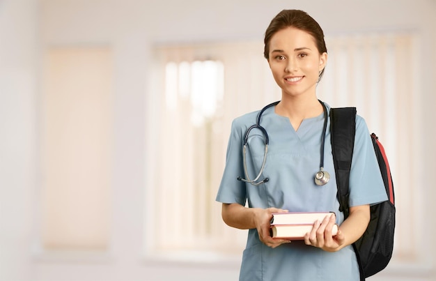 Attractive young female doctor student on background