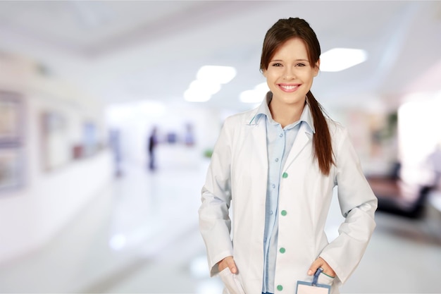 Attraente giovane dottoressa con interni sfocati dell'ospedale sullo sfondo