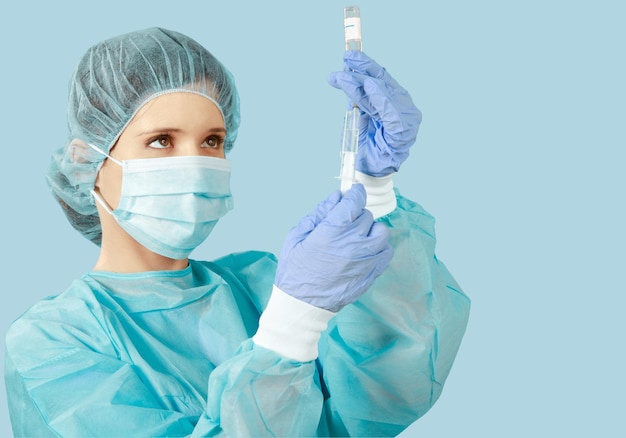 Attractive young female doctor with syringe on blurred hospital interior on background