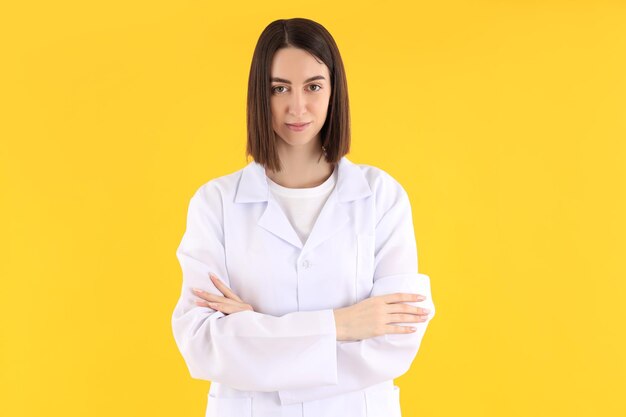 노란색 배경에 매력적인 젊은 여성 의사