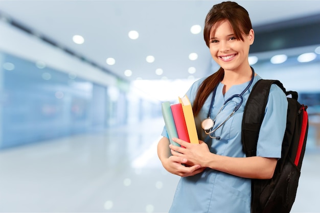 Привлекательная молодая студентка-медик с рюкзаком и книгами