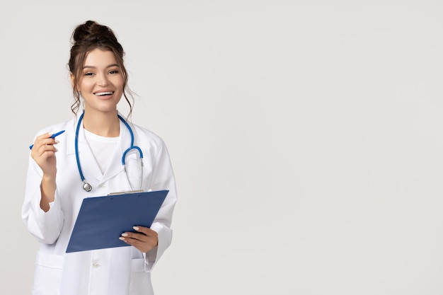 Attractive young girl in a doctors gown with a stethoscope