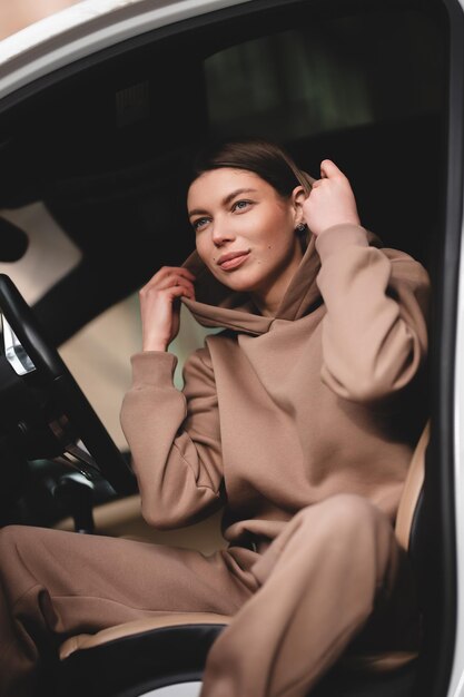 Attractive young girl driving a car The girl gets out of the car