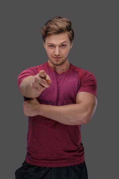 Attractive young guy in sportswear isolated on a grey background.