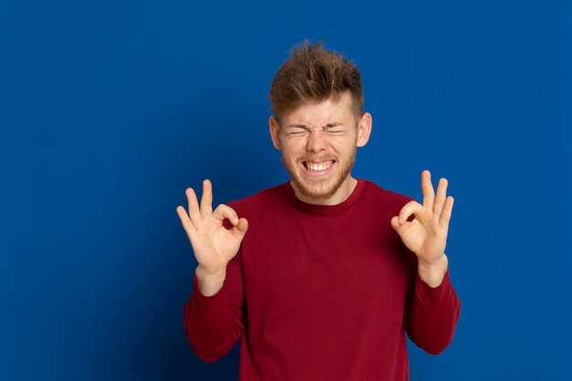 赤いTシャツを持つ魅力的な若い男