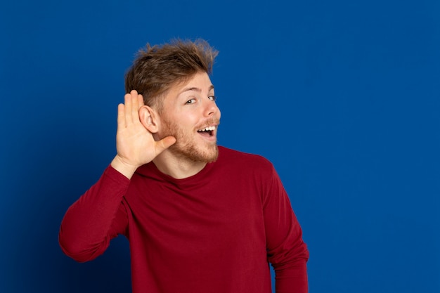 赤いTシャツを持つ魅力的な若い男