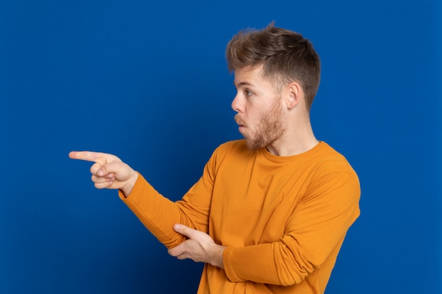 黄色のTシャツを持つ魅力的な若い男