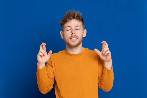 黄色のTシャツを持つ魅力的な若い男