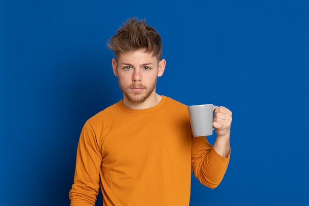 黄色のTシャツを持つ魅力的な若い男