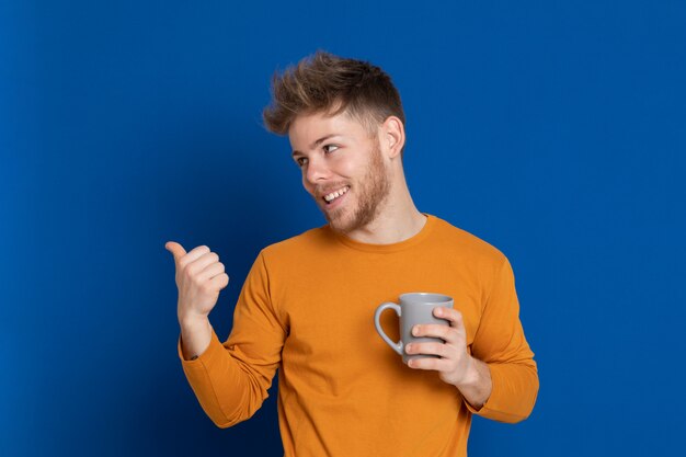 黄色のTシャツを持つ魅力的な若い男