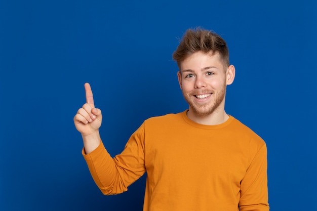 黄色のTシャツを持つ魅力的な若い男