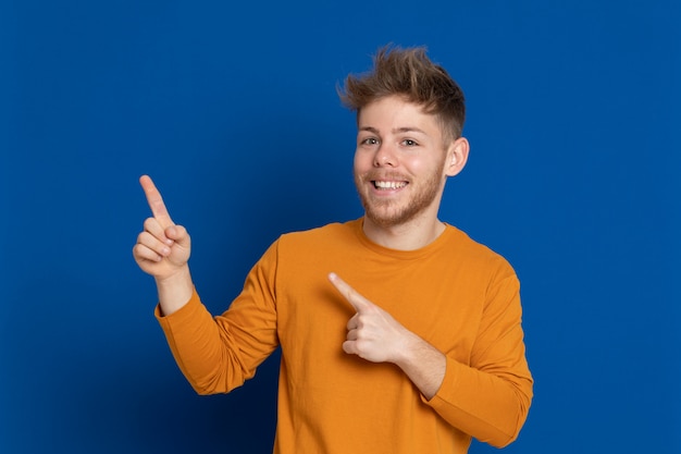 黄色のTシャツを持つ魅力的な若い男