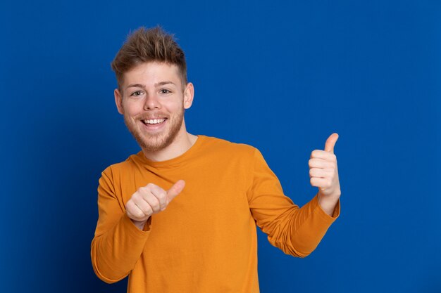 黄色のTシャツを持つ魅力的な若い男