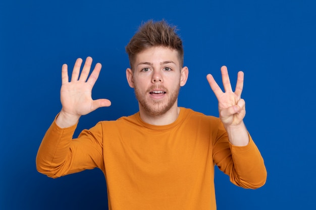 黄色のTシャツを持つ魅力的な若い男