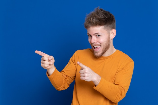 黄色のTシャツを持つ魅力的な若い男