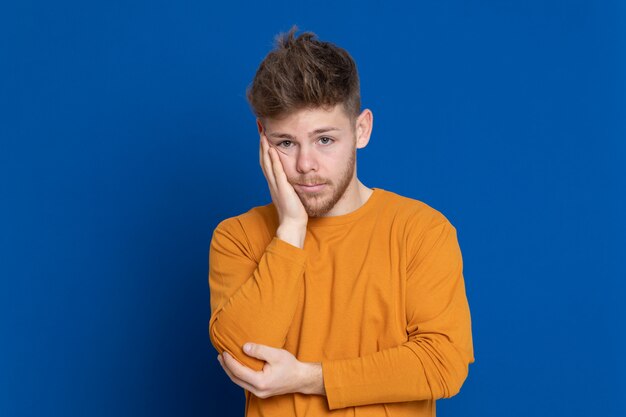 黄色のTシャツを持つ魅力的な若い男