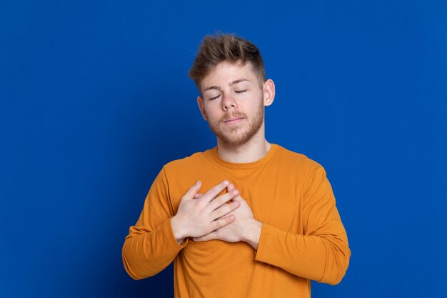 黄色のTシャツを持つ魅力的な若い男