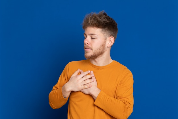 黄色のTシャツを持つ魅力的な若い男