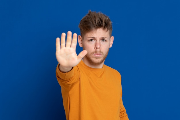 黄色のTシャツを持つ魅力的な若い男