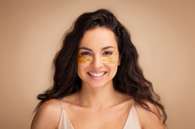 Attractive young indian woman using eye patches