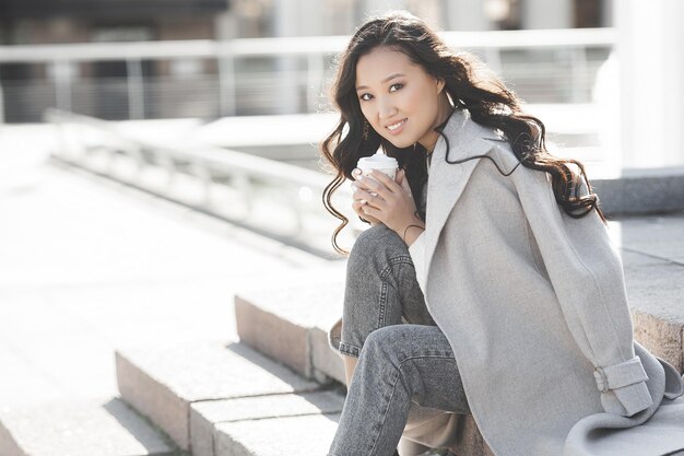 Attractive young lady drinking coffee. Beautiful young woman closeup portrait. Female facial portrait.