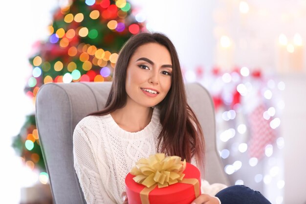 Attractive young lady with gift box at home