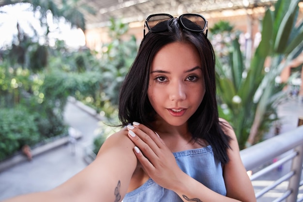 Attractive young latina taking a selfie with her smart phone