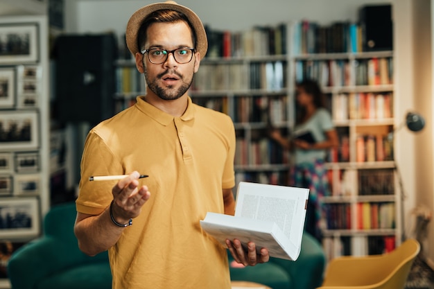 Attractive young male student in university library.