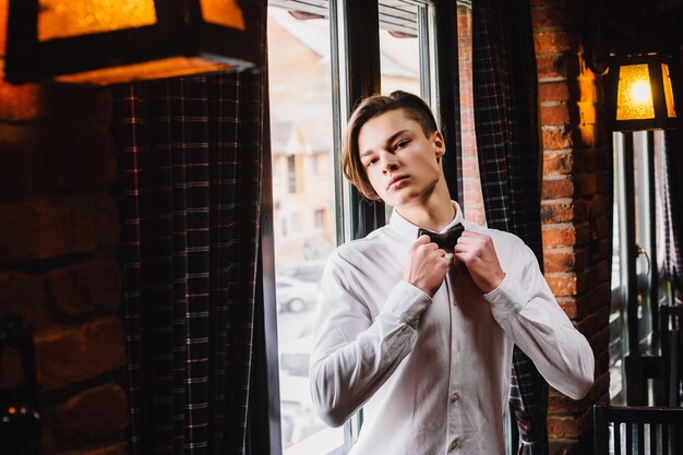 Attractive young man close up straightens his bow tie