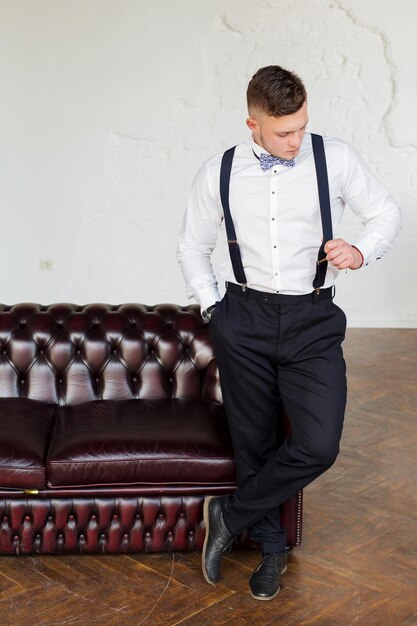 Attractive young man future generation businessman stand near\
sofa and interested in searching work