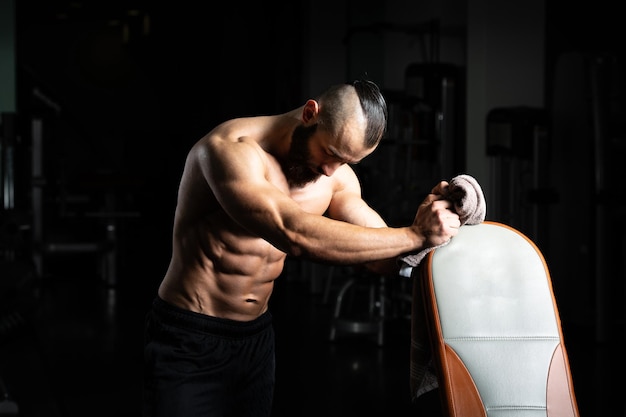 Photo attractive young man resting in gym afther exercise