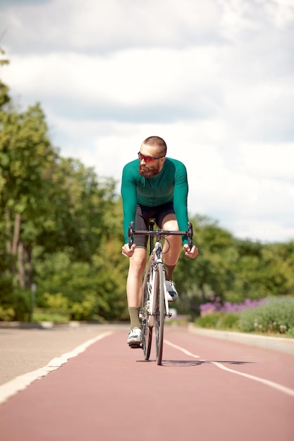 Foto il giovane attraente guida una bici