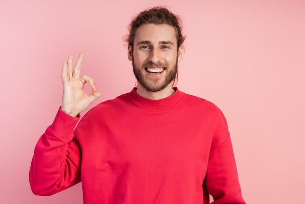 Attractive, young man shows okay, he is sincerely happy.