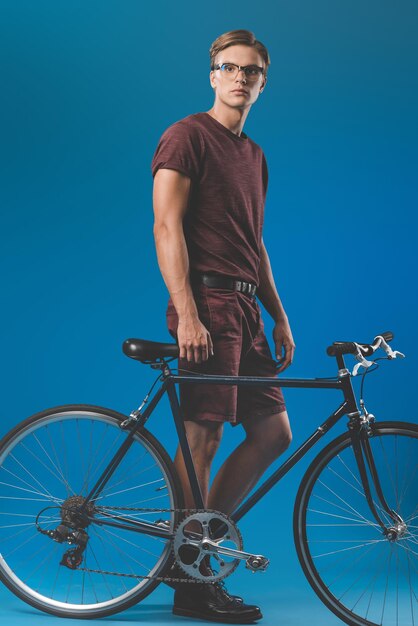 Attractive young man in stylish clothing with vintage bicycle