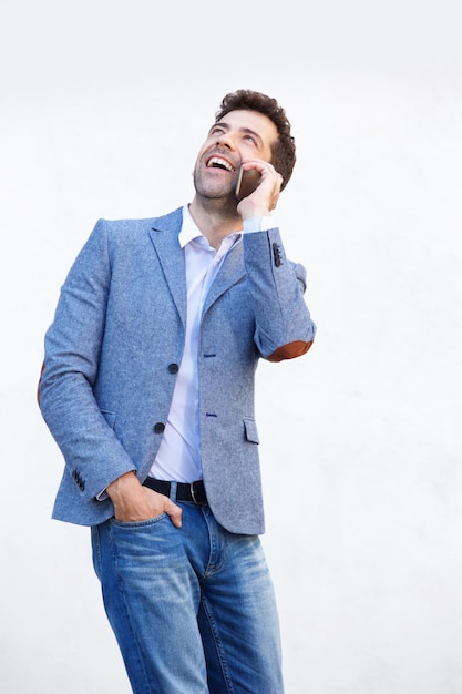 Attractive young man talking on mobile phone against white background