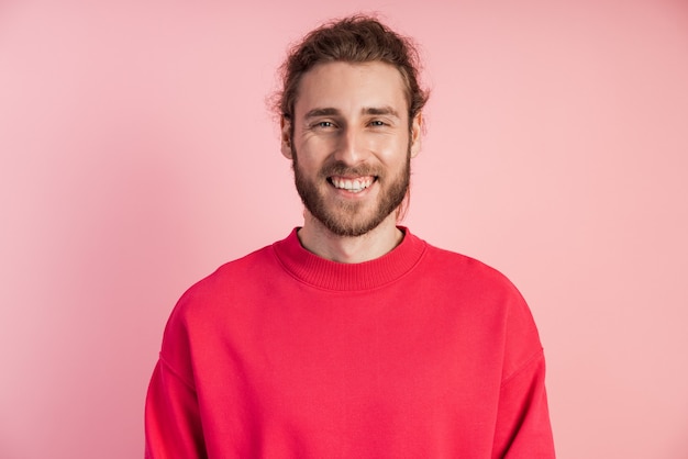 Attraente, giovane uomo con la barba in un pullover luminoso