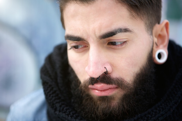 Attractive young man with beard and piercings