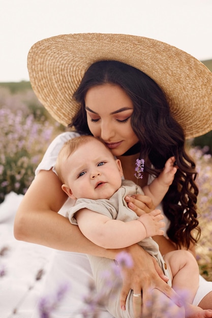 Attractive young mother playing with her baby in a lavender field