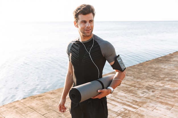 Attractive young sportsman in earphones