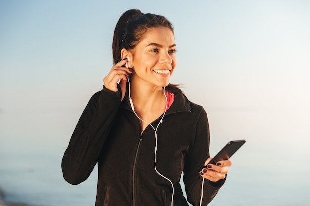 Attractive young sportswoman listening to music