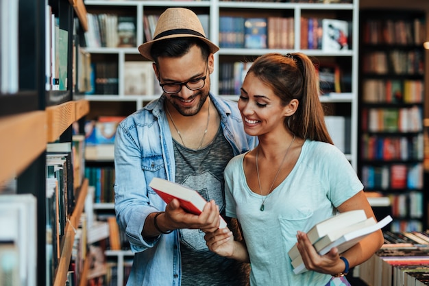 書店で本を選ぶ魅力的な若い学生の男性と女性。