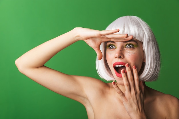 Attractive young topless woman wearing short white hair standing isolated, looking far away