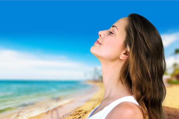 Attractive young woman on beach smiling