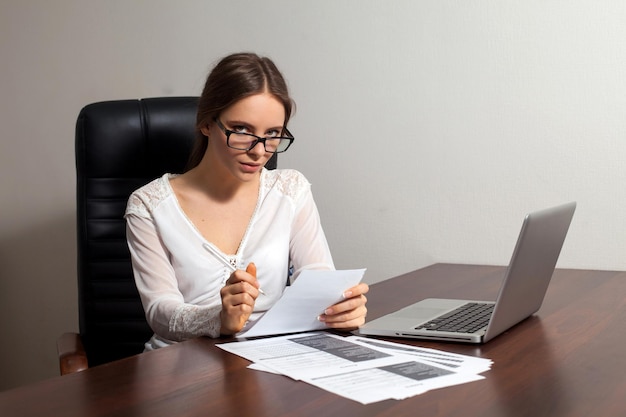 Attractive young woman boss is preparing for writting documents