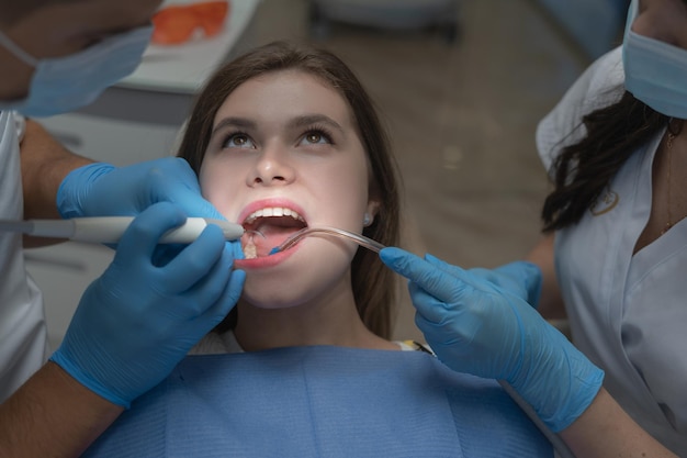남성 치과 의사와 치과에서 매력적인 젊은 여자. 건강한 치아 개념입니다.