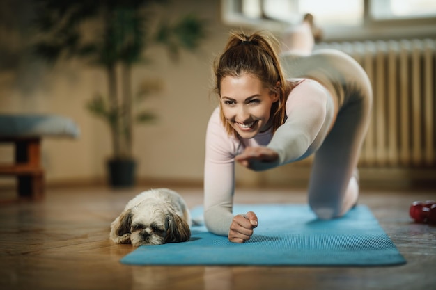 An attractive young woman doing plank exercises at home during the day.